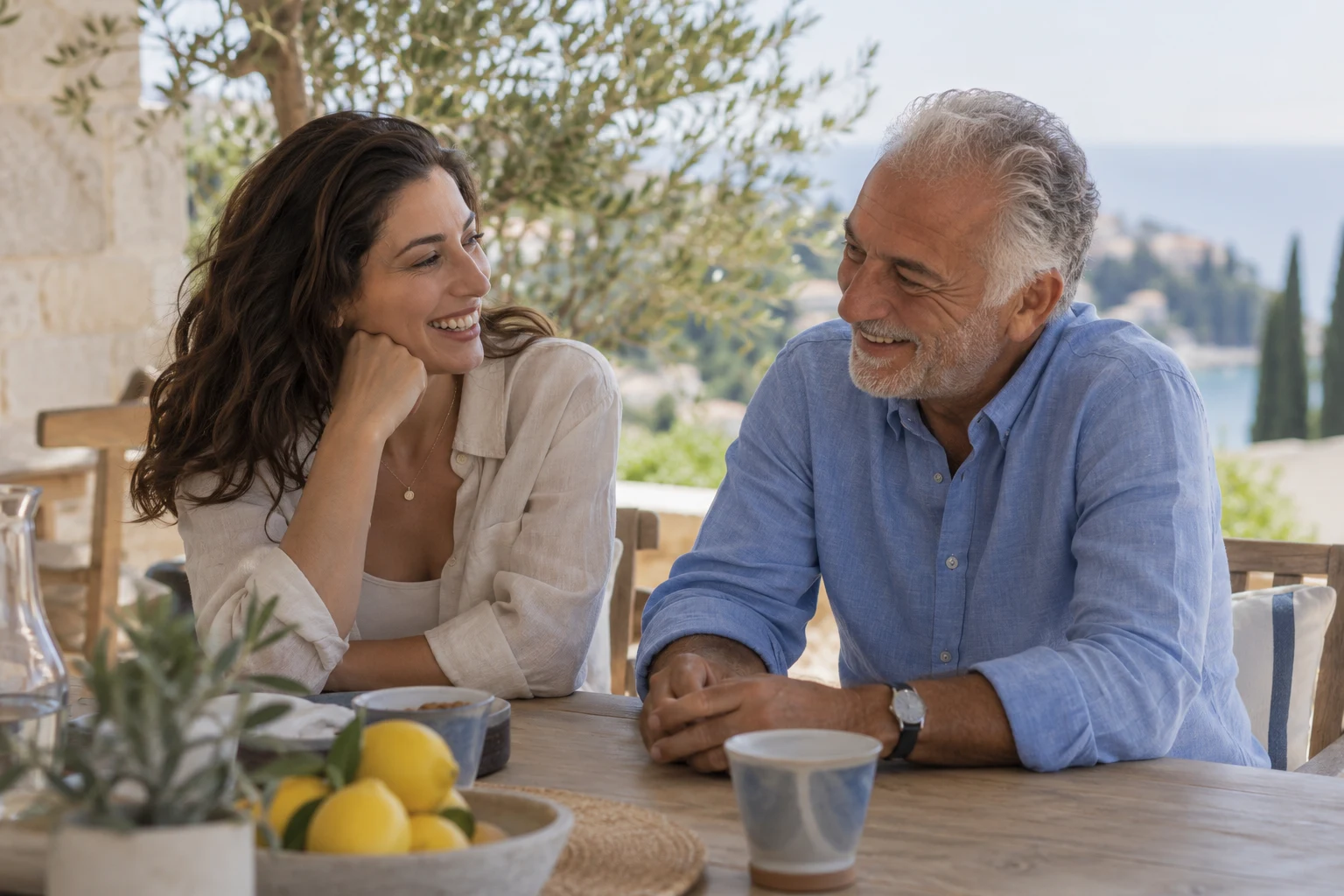 An adult daughter and her father sharing a laugh on a home terrace